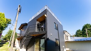 Una casa moderna de dos pisos con balcón, escalera y garaje.