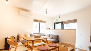 Una habitación moderna y bien iluminada con una mesa de comedor de madera, sillas, un sofá y un banco.