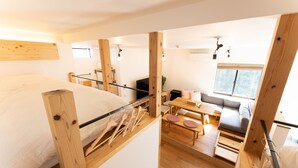 Una habitación compacta y moderna con cama, un pequeño comedor y un sofá.