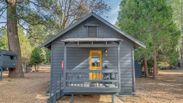 Une petite cabane avec une porte jaune, un porche et le chiffre « 10 » peint sur le côté.