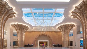 Eine geräumige Lobby mit hoher Decke, einem zentralen Kronleuchter und einem Oberlicht.