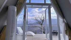 Une chambre moderne dotée d’une grande porte vitrée donnant sur une terrasse extérieure.