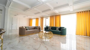 Un salón amplio con suelo de mármol, dos sofás, una mesa de centro y una puerta.