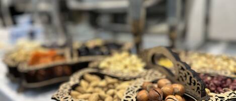 A variety of nuts in ornate containers on a table.