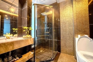 A modern bathroom with a glass shower enclosure, a marble vanity, and a toilet. - Jinxi Hotel (Olympic Sports Center Geological Museum Branch) (Guiyang)