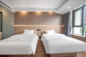 A hotel room with two beds, a wooden headboard, a nightstand, and a large window. - Jinxi Hotel (Olympic Sports Center Geological Museum Branch) (Guiyang)