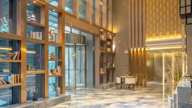 Um hall moderno com piso de mármore, vitrines de vidro e área de estar.