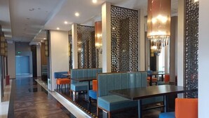 Um restaurante moderno com cabines e mesas, painéis decorativos na parede e iluminação ambiente.