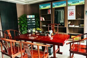 Un coin repas avec une table et des chaises en bois, entouré d’étagères et d’objets décoratifs.
