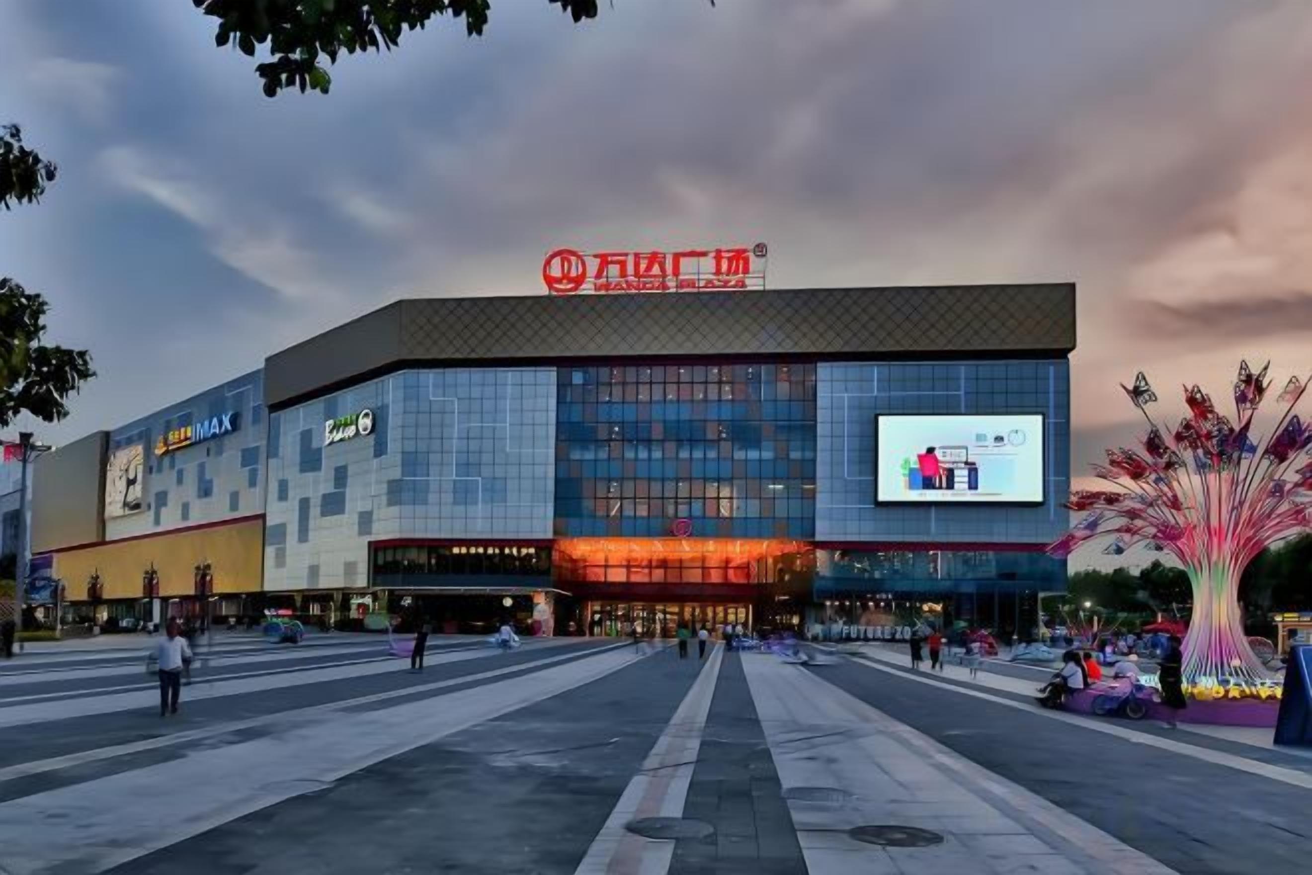 A large commercial building with a prominent sign and a digital billboard.