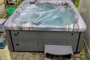 Un jacuzzi con revestimiento de madera y un banco en frente.