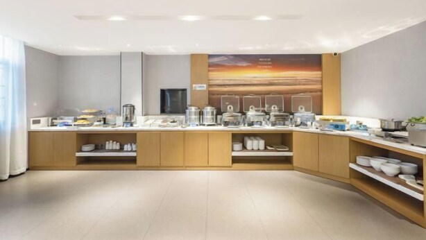 A modern kitchen with a breakfast bar, equipped with various appliances and storage cabinets. - Yeste Hotel (Yulin Jiangbin Road Cross Street) (Yulin)