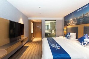 A hotel room with a large bed, a flat-screen TV mounted on the wall, and a poster of a cityscape. - Yeste Hotel (Yulin Jiangbin Road Cross Street) (Yulin)