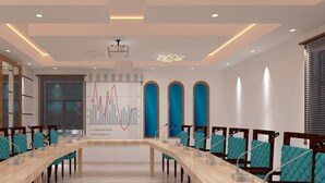 A conference room with a long table, chairs, and a presentation screen. - Corbett View Banquets and Resorts (Moradabad)