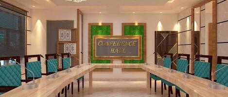Un salón de conferencias con largas mesas, sillas y un cartel que dice 'CONFERENCE HALL'.