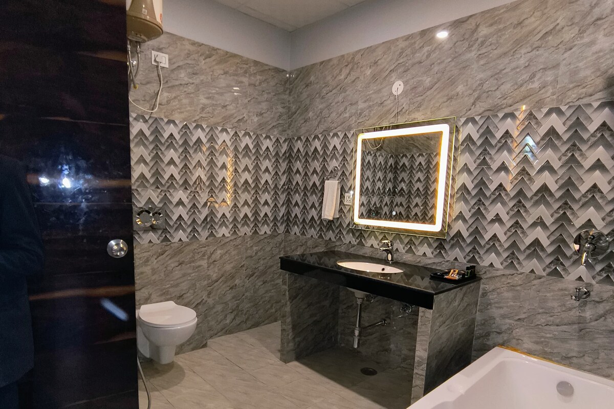 A modern bathroom with a large bathtub, a sink, and a toilet.