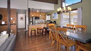 Una cocina amplia con armarios de madera, una isla central e iluminación colgante.