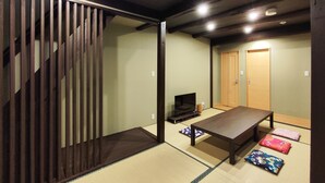 A traditional Japanese room with tatami flooring, a low table, cushions, a television, and sliding doors. - West Japan Kyoto Kiyomizu (Kyoto)