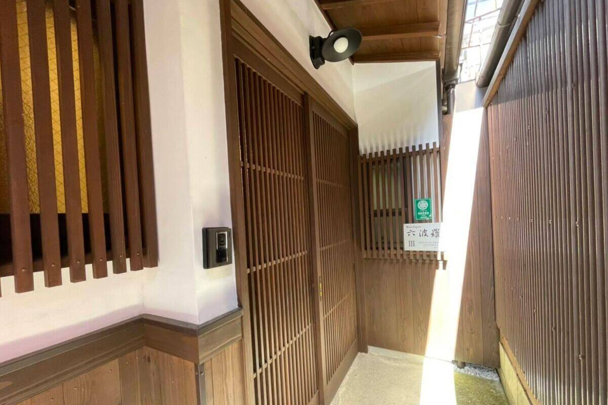 A traditional Japanese interior with sliding wooden doors, a small sign, and a ceiling fan.