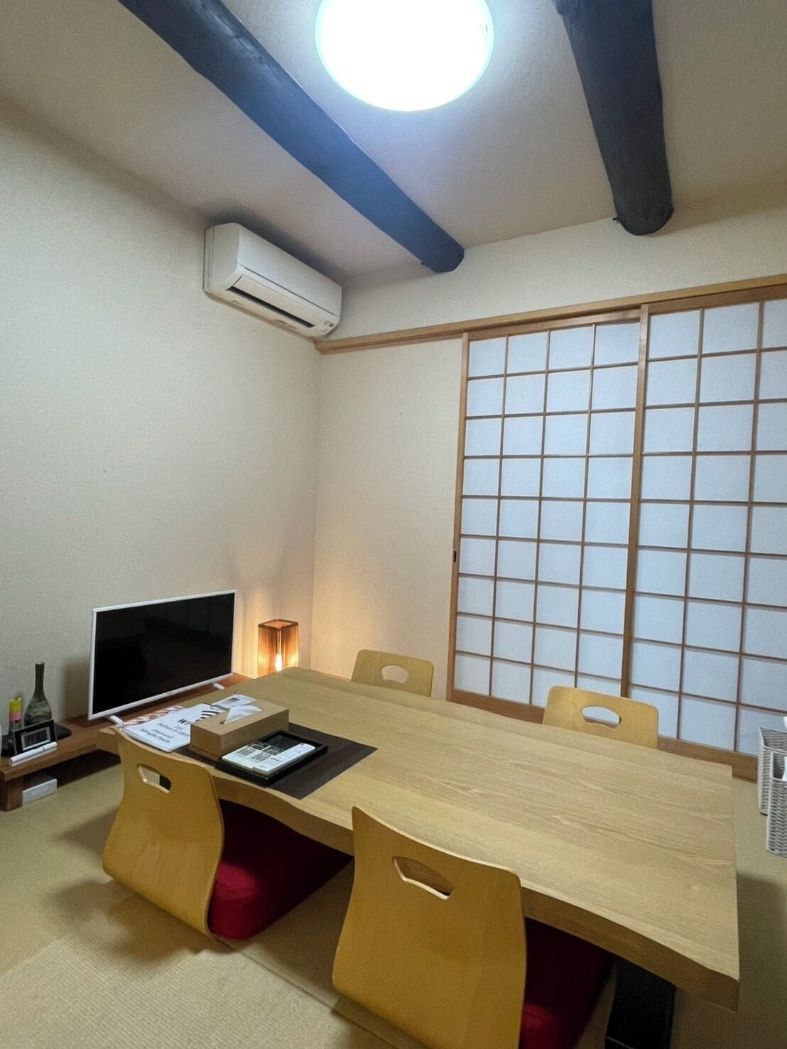 Una habitació japonesa tradicional amb fons de tatami, una taula baixa i panells shoji.
