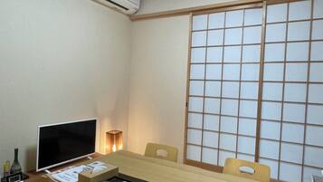 Una habitació japonesa tradicional amb fons de tatami, una taula baixa i panells shoji.