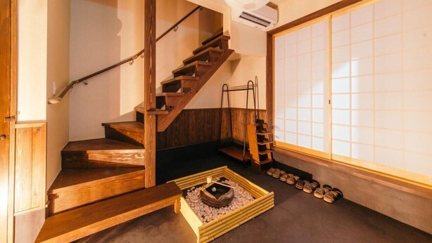 A traditional Japanese room with tatami flooring, a wooden staircase, a sliding door, and a small table with a bowl and chopsticks. - West Japan Kyoto Kiyomizu (Kyoto)