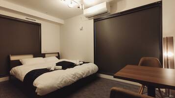 A hotel room with a bed, a desk, and a chair.