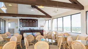A spacious dining area with high ceilings and large windows offering a view of the city.