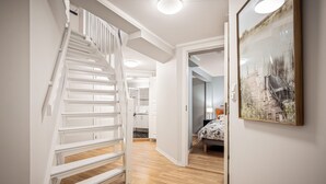 A staircase leading to a bedroom with a bed and a painting on the wall. - Rosen Apartment  (Bergen)