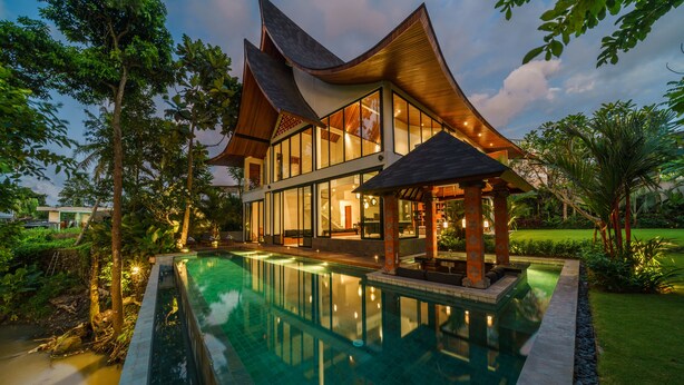 A modern house with a swimming pool, large windows, and a garden. - Villa Satiya (Munggu)