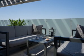 An outdoor seating area with a sofa, chairs, and a table.