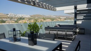 A terrace with a table, chairs, a sofa, and a potted plant. - Cala Serena  ·  Beautiful 3 bedroom apartment 850 meters from the beach in La Cala de Mijas (La Cala de Mijas)