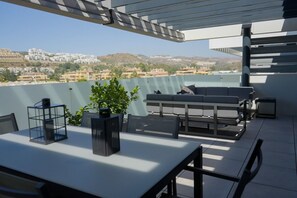 A terrace with a table, chairs, a sofa, and a potted plant. - Cala Serena  ·  Beautiful 3 bedroom apartment 850 meters from the beach in La Cala de Mijas (La Cala de Mijas)