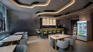 Un restaurante moderno con techo curvo, barra, asientos y dispensador de bebidas.
