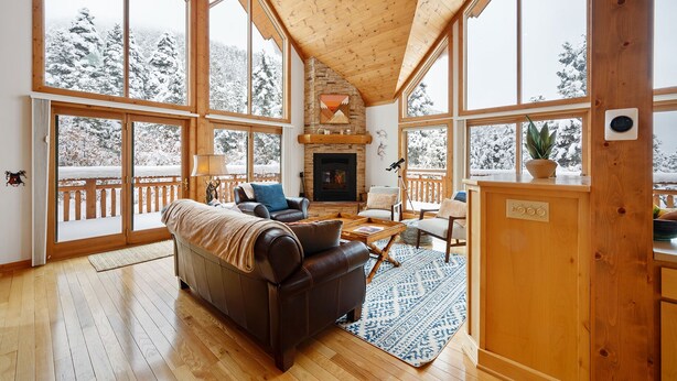 A spacious living room with a fireplace, large windows, and a cozy seating area.