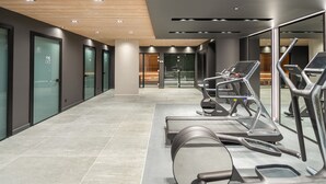 Una palestra moderna con tapis roulant, cyclette e uno specchio a parete.