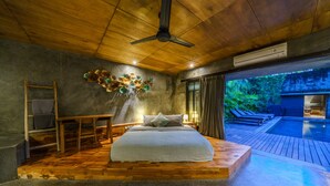 A bedroom with a wooden platform bed, a ceiling fan, and a view of an outdoor swimming pool. - Love Supreme Villa by Betterplace (Canggu)