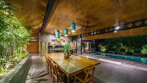 A spacious indoor area with a wooden dining table, chairs, and a ceiling fan. - Love Supreme Villa by Betterplace (Canggu)
