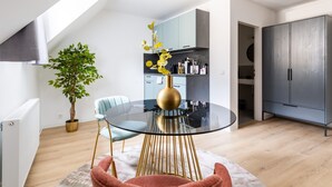 Une cuisine moderne dotée d’une lucarne, un coin repas avec une table en verre et une plante en pot.