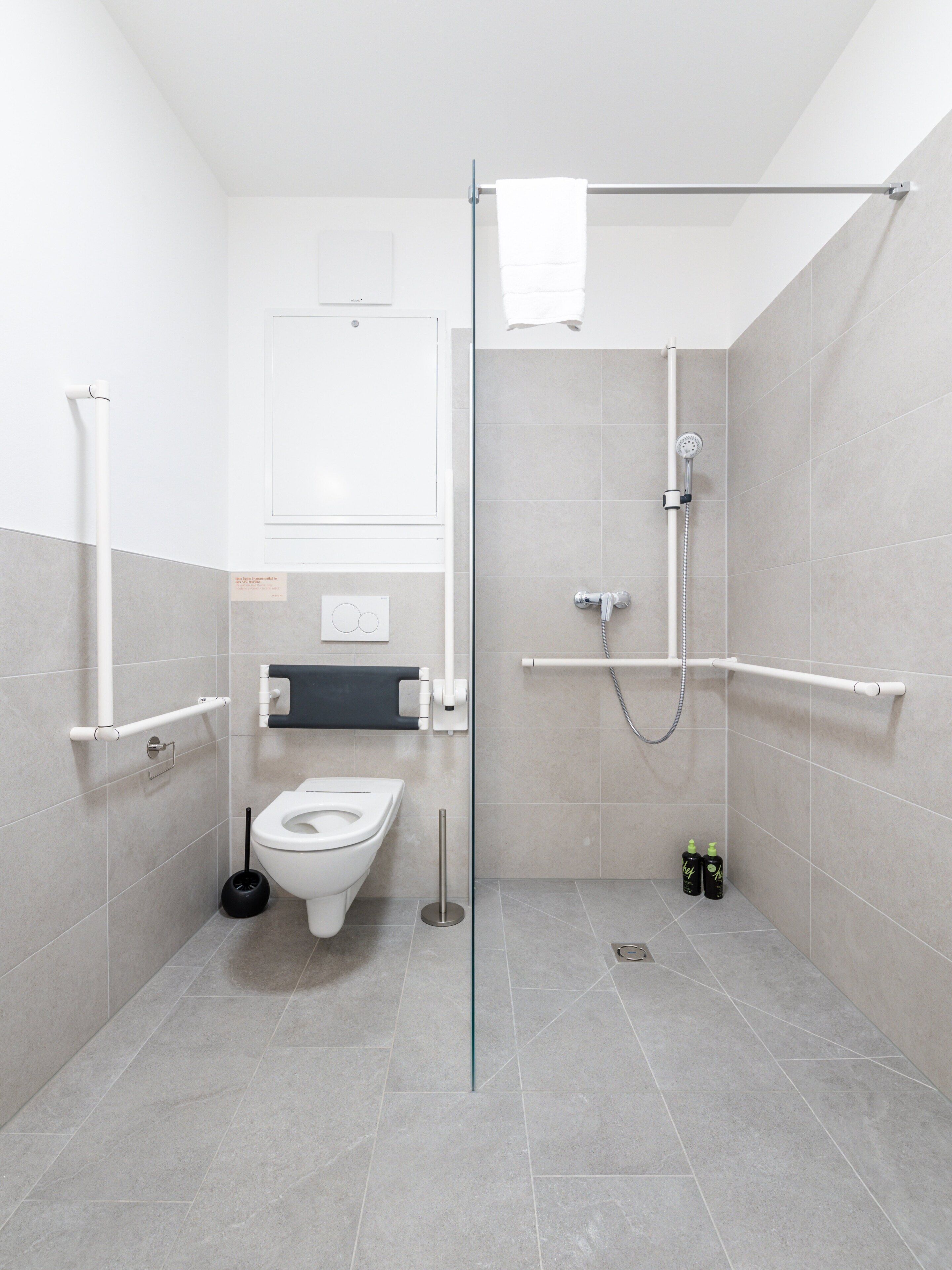Et moderne badeværelse med toilet, bidet og bruser.