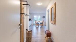 A hallway leading to a dining area with a table and chairs, a wicker basket, and a bench. - The Emma vacation apartment in St. Peter-Dorf for up to 4 people (St. Peter-Dorf)