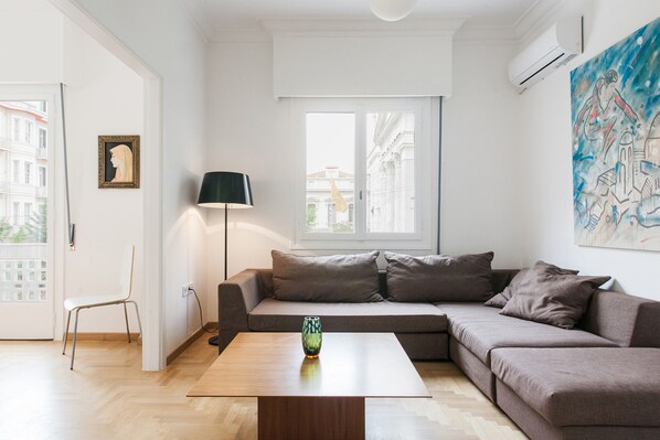Un salon moderne avec un canapé, une table basse et une lampe.