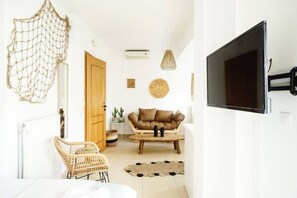En moderne stue med sofa, sofabord og en fletstol.