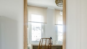 Een kamer met een spiegel met houten lijst, die een werkplek weerkaatst met een stoel en bureau.
