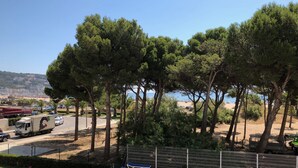 Un espace piscine avec des chaises longues et une vue sur la plage et la mer.