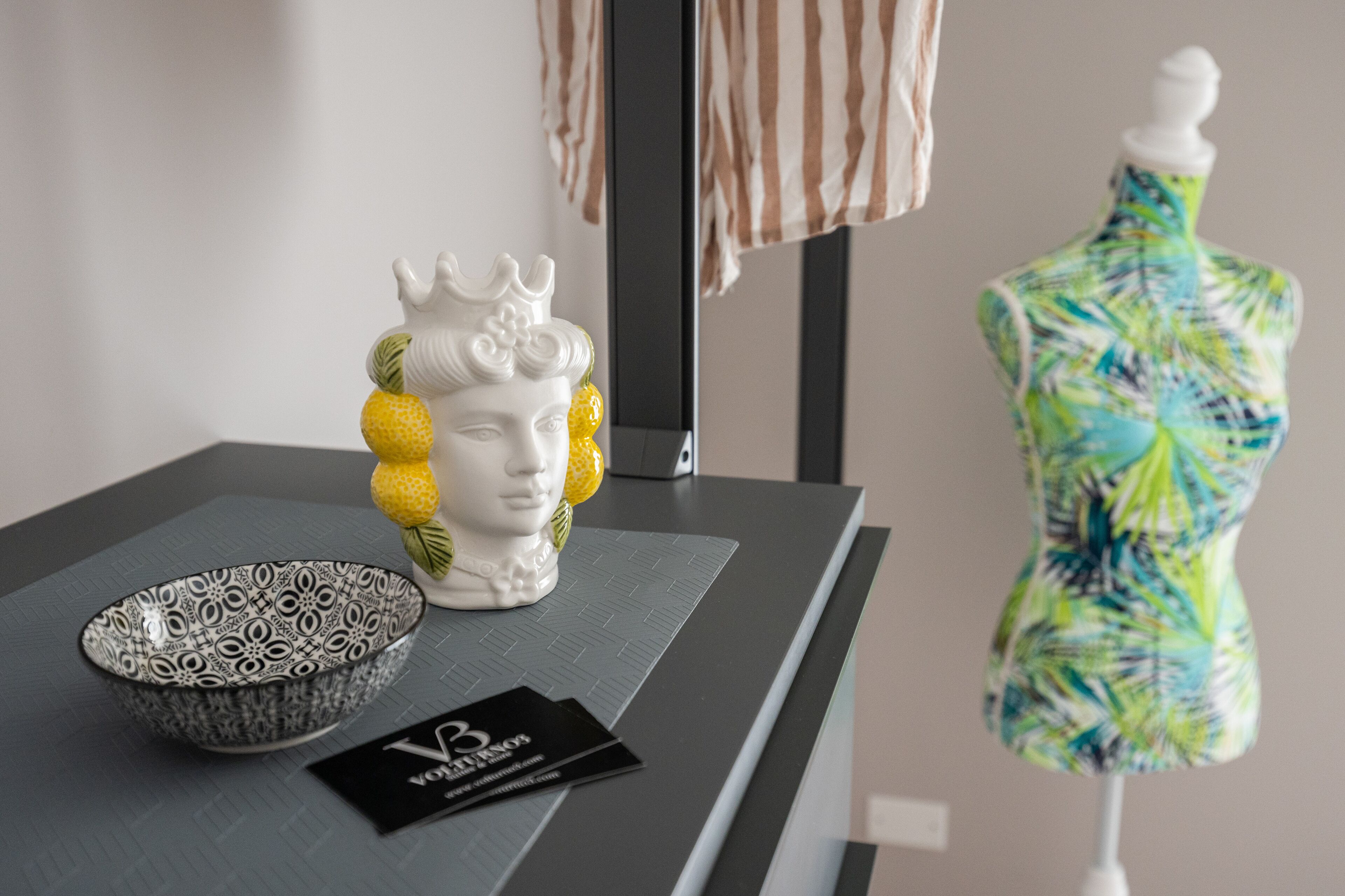 Une table sur laquelle se trouvent un bol décoré, une petite carte et une sculpture représentant une tête.