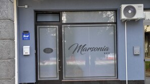 Ein Schaufenster mit einer großen Glasscheibe, auf der der Schriftzug "Marsonia" zu sehen ist und ein Schild daraufhinweist, dass es sich um ein Soba-Restaurant handelt.