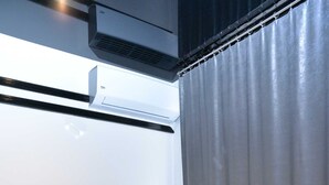 Ein modernes Zimmer mit einem beigen Sessel, einem kleinen Tisch, einer Topfpflanze und einer Bank.