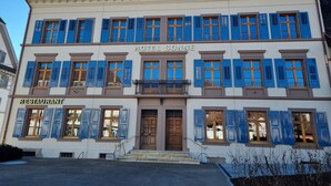 A hotel with a sign reading "HOTEL SONNE" and a restaurant below it. - Hotel Restaurant zur Sonne (Sissach)