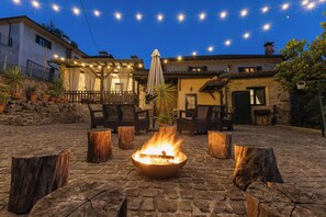 A courtyard with a fire pit, outdoor seating, and string lights. - Maisons des Fleurs, villa with pool in northern Portugal (Sande)
